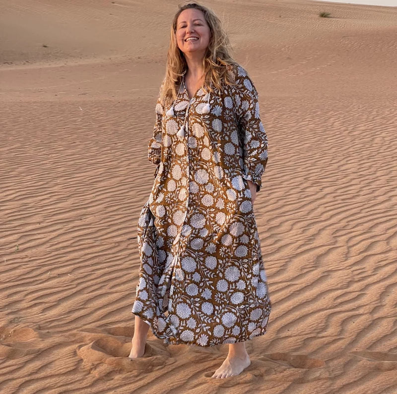 Woman wearing long hand block printed kaftan dress in Dubai Dessert.