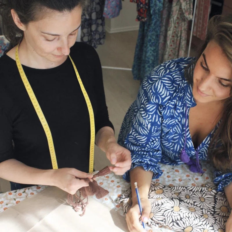 Seamstress and Designer planning new collection wearing block print dress. 