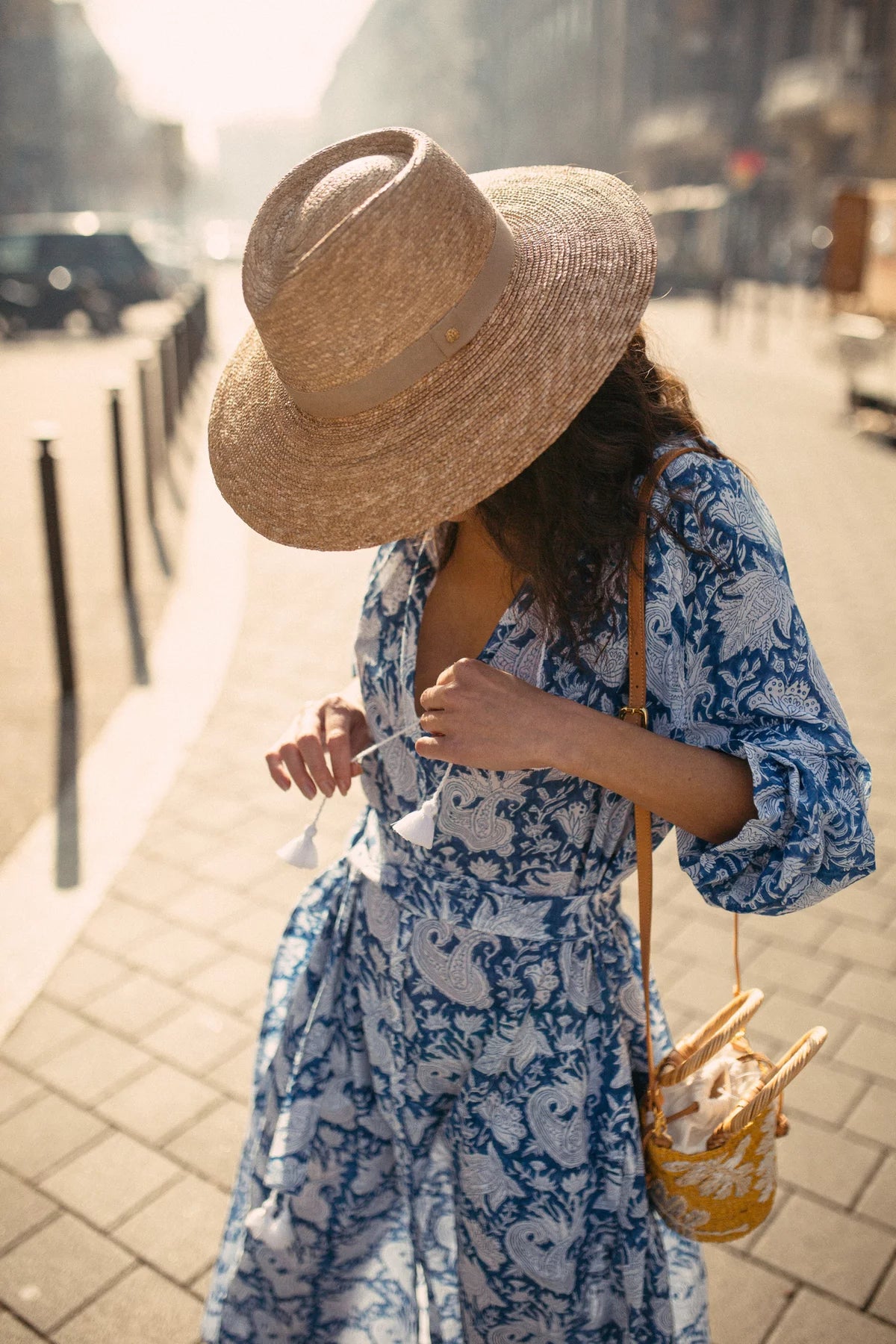 Woman wearing hand block printed long kaftan dress with straw hat summer time.